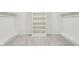 Spacious walk-in closet with built-in shelves, clothing rods, and neutral-colored carpeting at 5786 E Fall Creek Pkwy N Dr, Indianapolis, IN 46226