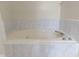 Jetted bathtub with marble surround and tile accents at 5988 White Birch Dr, Fishers, IN 46038