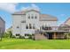 A well-maintained backyard features a spacious deck with outdoor seating, surrounded by green grass and manicured landscaping at 6078 Hardwick Dr, Whitestown, IN 46075