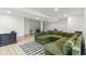Finished basement with a large green sectional couch, wood flooring, and a black and white rug at 6078 Hardwick Dr, Whitestown, IN 46075