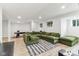 Finished basement with a large green sectional couch, wood flooring, and a pool table at 6078 Hardwick Dr, Whitestown, IN 46075