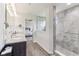Bright bathroom featuring a granite-topped double vanity and a walk-in shower with stylish gray tiling at 6078 Hardwick Dr, Whitestown, IN 46075