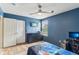 Blue bedroom featuring a dark dresser, light hardwood floors, a ceiling fan and a large window at 6078 Hardwick Dr, Whitestown, IN 46075