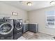 Laundry room equipped with front-loading washer and dryer, built-in cabinets and counter, and a window at 6078 Hardwick Dr, Whitestown, IN 46075