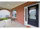 Inviting front porch with brick accents, seating area, and a stylish front door at 6078 Hardwick Dr, Whitestown, IN 46075