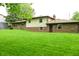 Expansive backyard featuring a lush lawn and brick and siding exterior at 6126 Rucker Rd, Indianapolis, IN 46220