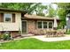 Home exterior featuring a patio area with a dining set, brick accents, and mature trees at 6126 Rucker Rd, Indianapolis, IN 46220