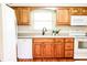 Bright kitchen with wooden cabinets, white appliances, and a window above the sink offering natural light at 6126 Rucker Rd, Indianapolis, IN 46220
