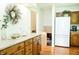 Bright kitchen with hardwood floors, white appliances, and wood cabinetry at 6126 Rucker Rd, Indianapolis, IN 46220
