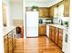 Updated kitchen features wooden cabinets, white appliances, and hardwood floors for a warm and inviting atmosphere at 6126 Rucker Rd, Indianapolis, IN 46220