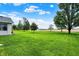 Large backyard with beautiful trees and well-maintained lawn next to a brick house at 6190 S 425 W, Pendleton, IN 46064