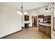 An open-concept kitchen with granite countertops and wood cabinets leading to a dining space and a view of the house interior at 6190 S 425 W, Pendleton, IN 46064