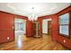 Elegant dining room with hardwood floors, decorative chandelier, and warm red walls at 6190 S 425 W, Pendleton, IN 46064