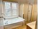 Bathroom featuring a garden tub, glass shower, and natural light from the window at 6242 Carrington Dr, Indianapolis, IN 46236