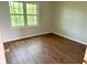 Charming bedroom with a window view and wood-look floors adding warmth to the space at 6242 Carrington Dr, Indianapolis, IN 46236