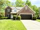 Charming two-story brick home with attached garage and a well-manicured front yard at 6242 Carrington Dr, Indianapolis, IN 46236