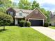 Traditional two-story home with brick and vinyl siding, attached garage, and landscaped front yard at 6242 Carrington Dr, Indianapolis, IN 46236