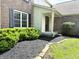 Close-up of house's entry, featuring manicured landscaping and a classic brick facade at 6242 Carrington Dr, Indianapolis, IN 46236