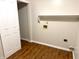 Bright laundry room with wood-look floors, convenient shelf, and washer/dryer hookups at 6242 Carrington Dr, Indianapolis, IN 46236