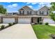 Charming townhome with a two-car garage, gray siding, brick accents, and a well-manicured lawn at 6463 Wasco Dr, Whitestown, IN 46075
