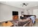 Cozy living room with a sectional sofa, TV, ceiling fan, and hardwood floors at 6463 Wasco Dr, Whitestown, IN 46075