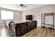 Bright living room with a large sectional sofa, TV, ceiling fan, and hardwood floors at 6463 Wasco Dr, Whitestown, IN 46075