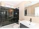 Modern bathroom featuring a luxurious black tiled shower, contemporary sink and vanity, and a stylish, well-lit mirror at 6471 Hunters Green Pl, Indianapolis, IN 46278