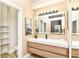 Contemporary bathroom with a wood vanity, illuminated mirror, and sleek fixtures, offering a spa-like experience at 6471 Hunters Green Pl, Indianapolis, IN 46278