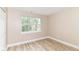 Bright bedroom featuring wood-look floors, a window providing views of the outside, and a neutral color scheme at 6471 Hunters Green Pl, Indianapolis, IN 46278