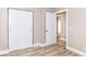 Neutral bedroom featuring wood-look floors, a closet with sliding doors, and a convenient open door leading to another room at 6471 Hunters Green Pl, Indianapolis, IN 46278