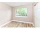 Bedroom with wood-look flooring, neutral walls, closet and view of the outdoors at 6471 Hunters Green Pl, Indianapolis, IN 46278
