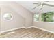 Attic bedroom featuring wood-look floors, a fan, and two windows letting in light and outside views at 6471 Hunters Green Pl, Indianapolis, IN 46278