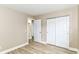 Bright bedroom with wood-look floors, a convenient closet with sliding doors, and an open doorway leading to another space at 6471 Hunters Green Pl, Indianapolis, IN 46278