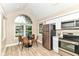 Bright kitchen with stainless steel appliances, dining area, and large windows at 6471 Hunters Green Pl, Indianapolis, IN 46278