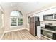 Sunlit kitchen showcases stainless steel appliances, white cabinetry, and a large arched window at 6471 Hunters Green Pl, Indianapolis, IN 46278