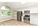 Bright eat-in kitchen features stainless steel appliances, white cabinets, and a large arched window at 6471 Hunters Green Pl, Indianapolis, IN 46278