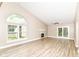 Spacious living room featuring a vaulted ceiling, large windows, a fireplace, and access to the outdoors at 6471 Hunters Green Pl, Indianapolis, IN 46278
