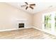 Bright living room boasts a fireplace, ceiling fan, French doors to the patio, and modern flooring at 6471 Hunters Green Pl, Indianapolis, IN 46278