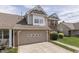View of a two-story home featuring a brick-accented garage, vinyl siding, and a well-maintained lawn at 6542 E Edna Mills Dr, Camby, IN 46113