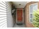 Inviting front entrance featuring a vibrant orange door, brick accents, and decorative wall art at 6542 E Edna Mills Dr, Camby, IN 46113