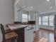 Bright kitchen with an island bar, stainless steel appliances, white cabinets, and hardwood floors at 6542 E Edna Mills Dr, Camby, IN 46113