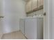 This laundry room has wooden cabinets above a white washer and dryer at 6542 E Edna Mills Dr, Camby, IN 46113