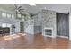 Open-concept living space with hardwood floors, a stone fireplace, and a view of the second-floor loft at 6542 E Edna Mills Dr, Camby, IN 46113