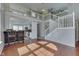 Bright open-concept living area with hardwood floors, stairs to the loft, and adjacent kitchen at 6542 E Edna Mills Dr, Camby, IN 46113