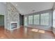 Spacious living room featuring a stone fireplace, hardwood floors, and a door to the outside at 6542 E Edna Mills Dr, Camby, IN 46113