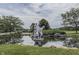 Picturesque view of a pond with a statue, lush greenery, and surrounding trees at 6542 E Edna Mills Dr, Camby, IN 46113
