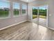 Bright living room featuring hardwood flooring, neutral walls, and an exterior sliding glass door at 6847 Cardiff Dr, McCordsville, IN 46055