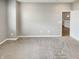 Spacious carpeted living room with light gray walls and connecting hallway at 6847 Cardiff Dr, McCordsville, IN 46055