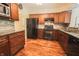 Well-appointed kitchen featuring dark wood cabinets, stone backsplash, and modern appliances at 7155 Sea Pine Dr, Indianapolis, IN 46250