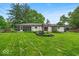 Beautifully landscaped backyard with lush green lawn, patio, and mature trees at 7316 Lesley Ave, Indianapolis, IN 46250
